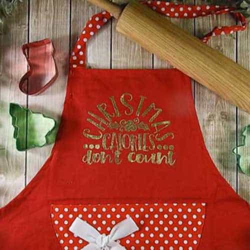 Make this cute heat embossed Apron for Christmas with this easy to follow tutorial. With a few tools and your Silhouette or Cricut machine, you'll be able to create this heat embossed Apron. This DIY project is easy and quick to make and is the perfect decoration for home. #ChristmasSilhouette #ChristmasCricut #ChristmasSVG