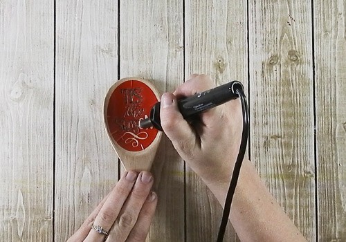 Person Holding a Wood Burning Tool, Burning Letters onto Wood