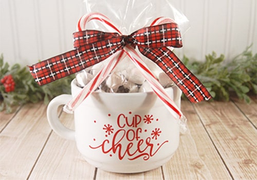 These hot chocolate gift mugs are the perfect Christmas gift for neighbors, teachers, family and friends. With a few tools and your Silhouette or Cricut machine, you'll be able to create these darling gift mugs. This DIY project is easy and quick to make and is the perfect gift for Christmas. #ChristmasSilhouette #ChristmasCricut #ChristmasSVG