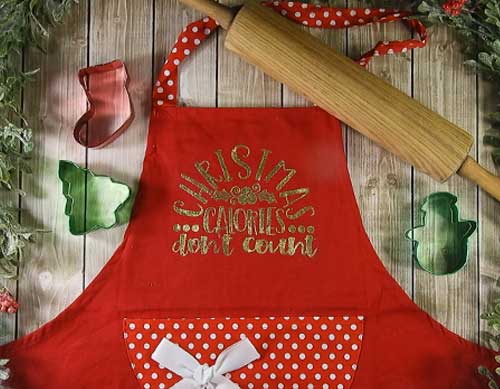 Make this cute heat embossed Apron for Christmas with this easy to follow tutorial. With a few tools and your Silhouette or Cricut machine, you'll be able to create this heat embossed Apron. This DIY project is easy and quick to make and is the perfect decoration for home. #ChristmasSilhouette #ChristmasCricut #ChristmasSVG