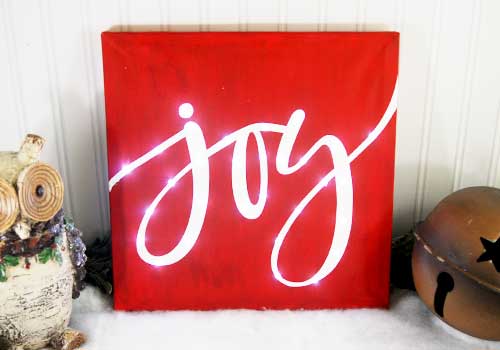 Make your own custom Lighted Christmas Canvas with your Silhouette or Cricut machine. This DIY project is easy and quick to make and is the perfect decoration for home. #ChristmasSilhouette #ChristmasCricut #ChristmasSVG #Christmascanvas